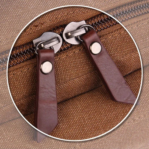 Close-up of brown canvas bag zipper with dual leather pulls, Orin & Vale accessory detail