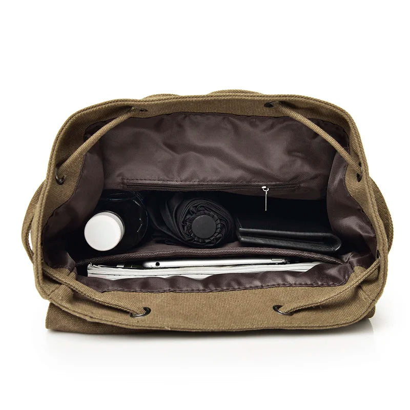 Open brown canvas bag with organized compartments, visible water bottle, umbrella, tablet, and pouch