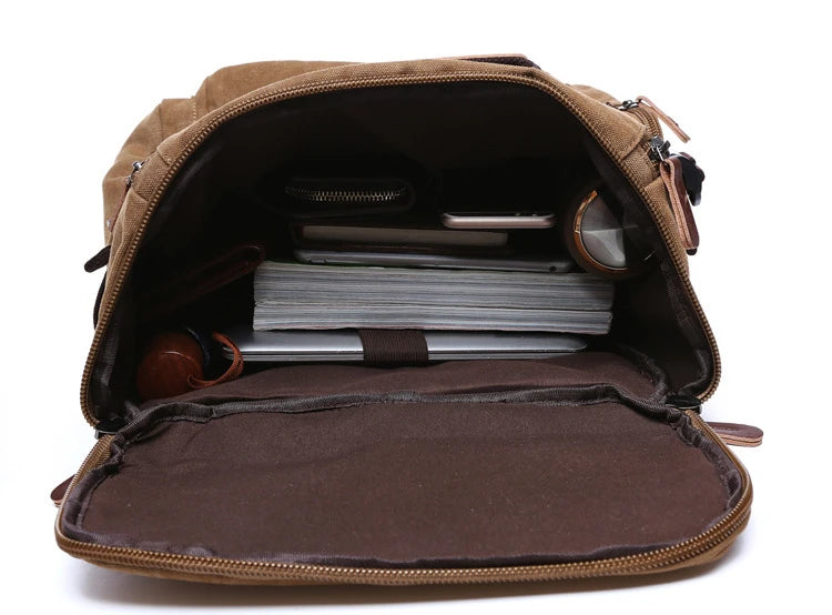 Open brown backpack with organized compartments, books, and accessories inside, Orin & Vale