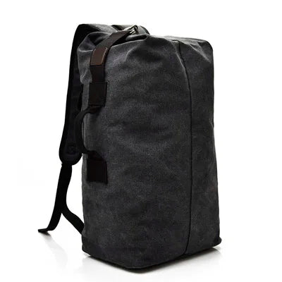 Minimalist black canvas backpack with brown accents, displayed against a white background