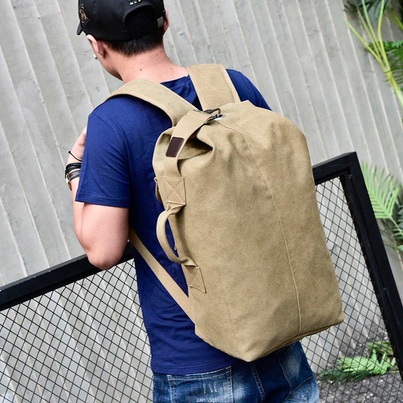 Man wearing a large tan canvas backpack outdoors, Orin & Vale casual style
